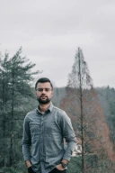 a man standing in front of trees